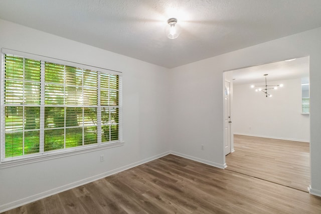 31115 Perlican Dr, Spring, TX 77386 - unfurnished room with wood finished floors, baseboards, and a chandelier