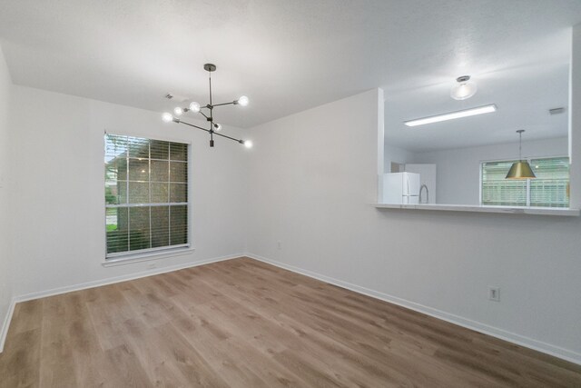 31115 Perlican Dr, Spring, TX 77386 - unfurnished dining area with wood finished floors, a chandelier, and baseboards