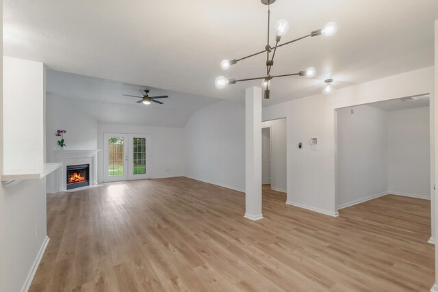31115 Perlican Dr, Spring, TX 77386 - unfurnished living room featuring a chandelier, a warm lit fireplace, light wood-type flooring, baseboards, and lofted ceiling