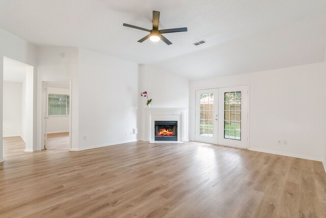 31115 Perlican Dr, Spring, TX 77386 - unfurnished living room featuring a ceiling fan, a lit fireplace, light wood-type flooring, vaulted ceiling, and baseboards
