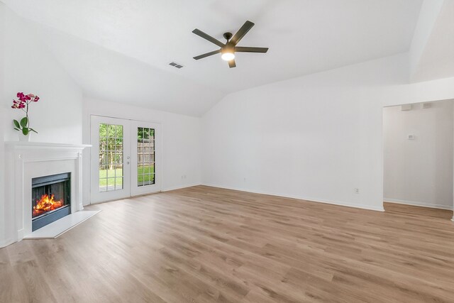 31115 Perlican Dr, Spring, TX 77386 - unfurnished living room featuring a ceiling fan, vaulted ceiling, a warm lit fireplace, light wood-type flooring, and baseboards