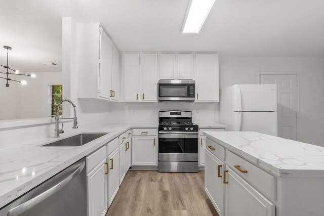 31115 Perlican Dr, Spring, TX 77386 - kitchen featuring stainless steel appliances, a sink, light wood-type flooring, and white cabinets