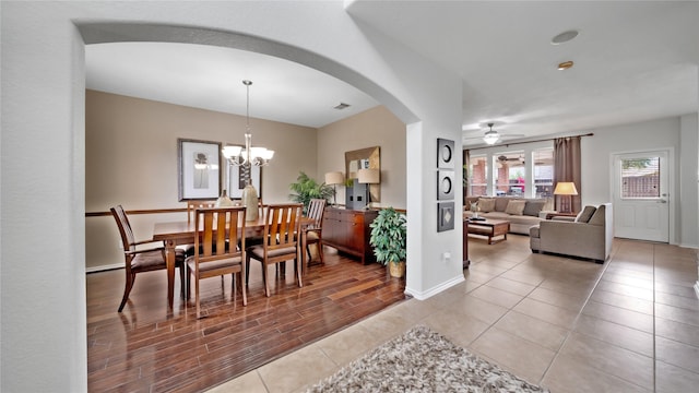 13703 View Meadow Ln, Houston, TX 77034 - dining space with arched walkways, ceiling fan, baseboards, light tile patterned floors, and a chandelier