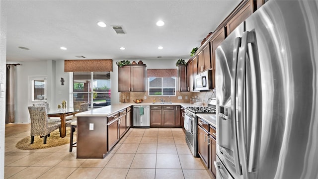 13703 View Meadow Ln, Houston, TX 77034 - kitchen featuring appliances with stainless steel finishes, a peninsula, decorative backsplash, recessed lighting, and a sink
