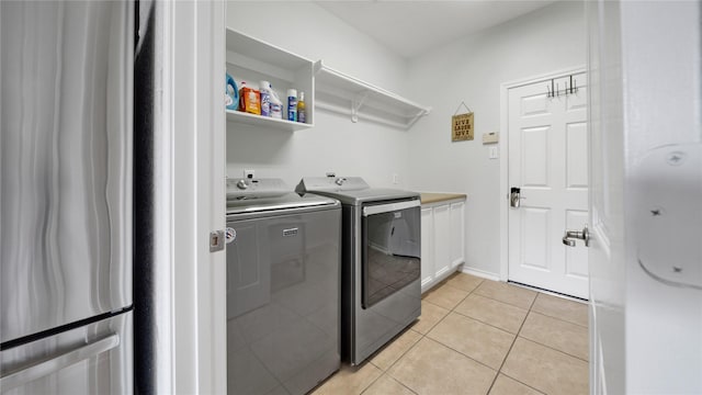 13703 View Meadow Ln, Houston, TX 77034 - laundry room featuring washing machine and dryer, cabinet space, and light tile patterned floors