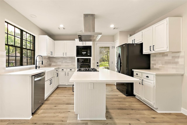 50 E Copper Sage Cir, The Woodlands, TX 77381 - kitchen featuring island range hood, black appliances, a kitchen island, tasteful backsplash, and recessed lighting