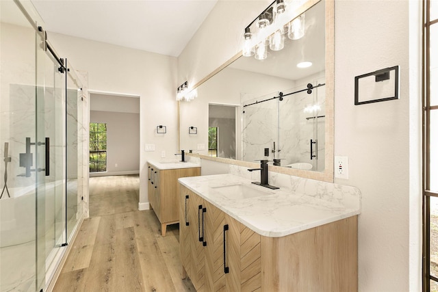 50 E Copper Sage Cir, The Woodlands, TX 77381 - full bath with a marble finish shower, wood finished floors, two vanities, and baseboards