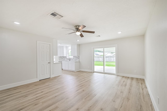 1210 E Rutgers Ln, Deer Park, TX 77536 - unfurnished living room featuring light wood-style floors, a ceiling fan, baseboards, recessed lighting, and a sink