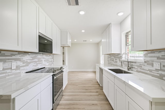 1210 E Rutgers Ln, Deer Park, TX 77536 - kitchen featuring appliances with stainless steel finishes, a sink, backsplash, light wood-style floors, and recessed lighting