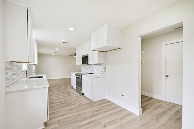 1210 E Rutgers Ln, Deer Park, TX 77536 - kitchen with a sink, electric stove, tasteful backsplash, baseboards, and light wood-style flooring