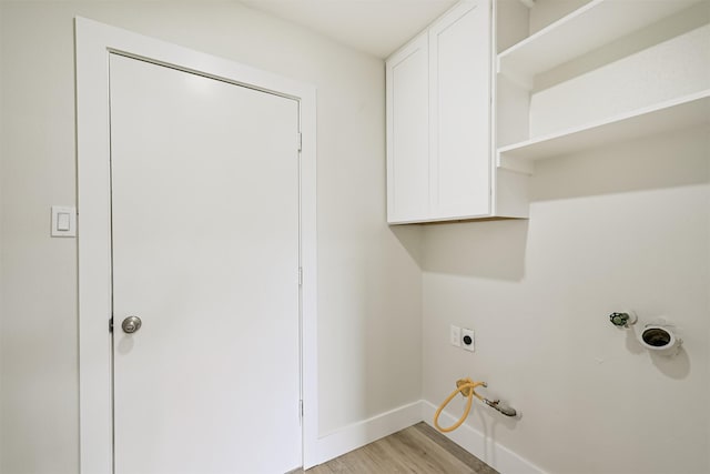 1210 E Rutgers Ln, Deer Park, TX 77536 - laundry area featuring cabinet space, hookup for an electric dryer, baseboards, light wood-style floors, and hookup for a gas dryer