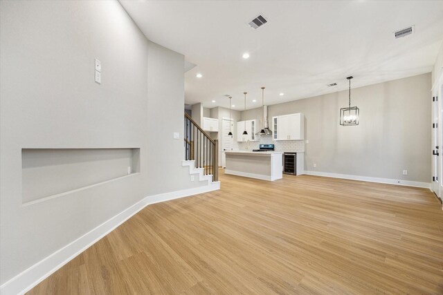 807 Martin St Unit D, Houston, TX 77018 - unfurnished living room with light wood finished floors, recessed lighting, baseboards, stairway, and a chandelier