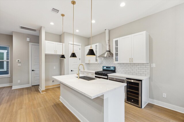 807 Martin St Unit D, Houston, TX 77018 - kitchen with wine cooler, a sink, stainless steel gas range oven, backsplash, and light wood-type flooring