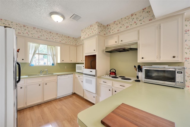 10722 Glenway Dr, Houston, TX 77070 - kitchen featuring white appliances, under cabinet range hood, a sink, light wood-type flooring, and light countertops
