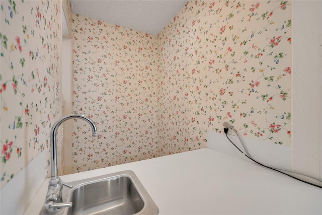 10722 Glenway Dr, Houston, TX 77070 - laundry room with wallpapered walls, a sink, and a textured ceiling