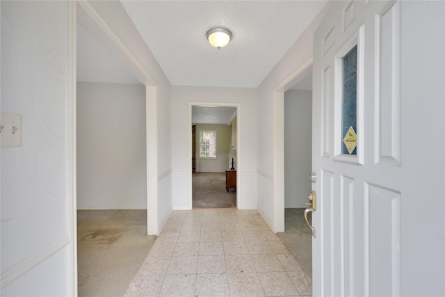 10722 Glenway Dr, Houston, TX 77070 - corridor featuring a textured ceiling, baseboards, and light carpet