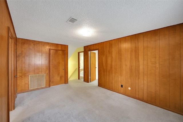 10722 Glenway Dr, Houston, TX 77070 - unfurnished bedroom featuring wood walls, carpet floors, and a textured ceiling