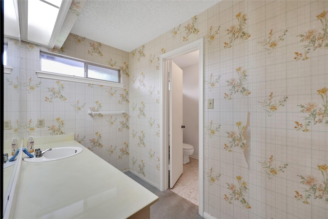 10722 Glenway Dr, Houston, TX 77070 - bathroom with toilet, vanity, baseboards, and a textured ceiling