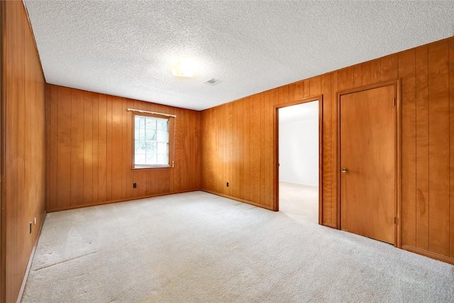 10722 Glenway Dr, Houston, TX 77070 - empty room with carpet flooring, a textured ceiling, and wooden walls