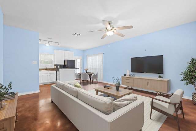 615 Columbus St, College Station, TX 77840 - living area with a ceiling fan, baseboards, finished concrete flooring, and rail lighting