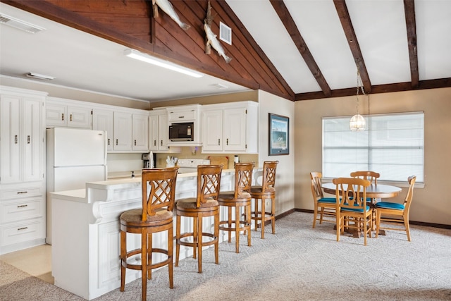 215 Selkirk Rd, Matagorda, TX 77414 - kitchen featuring black microwave, white cabinets, baseboards, and a peninsula