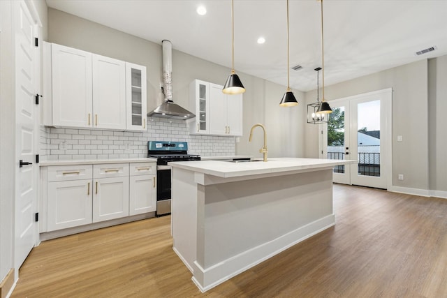 807 Martin St Unit C, Houston, TX 77018 - kitchen featuring gas stove, a sink, wall chimney range hood, tasteful backsplash, and light wood-style flooring