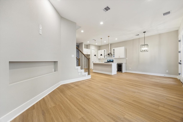 807 Martin St Unit C, Houston, TX 77018 - unfurnished living room with recessed lighting, light wood-type flooring, baseboards, stairway, and a chandelier