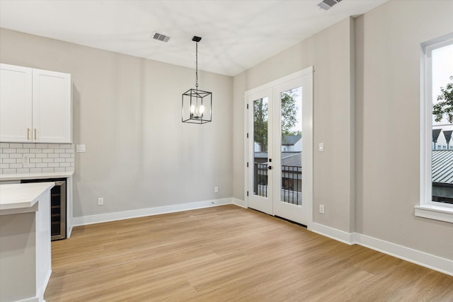 807 Martin St Unit C, Houston, TX 77018 - unfurnished dining area with french doors, light wood-style flooring, baseboards, and a chandelier