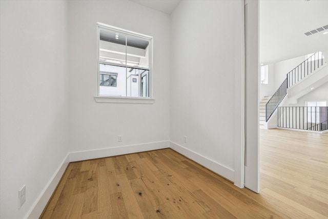2209 Dennis St, Houston, TX 77004 - spare room featuring wood finished floors, baseboards, and stairs