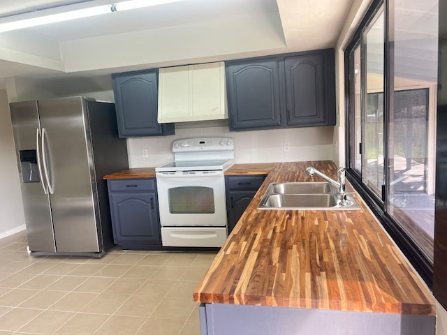 15730 Corsair Rd, Houston, TX 77053 - kitchen featuring wood counters, stainless steel fridge, white range with electric stovetop, a sink, and light tile patterned floors