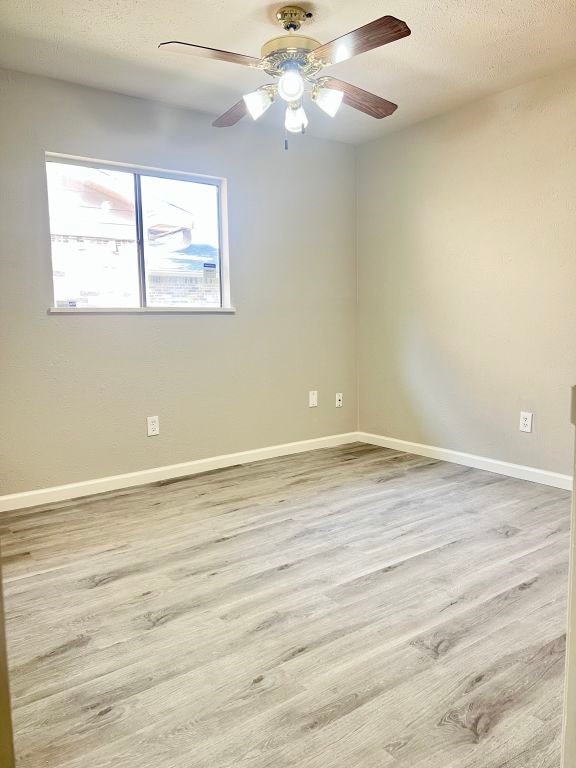15730 Corsair Rd, Houston, TX 77053 - spare room with baseboards, wood finished floors, a ceiling fan, and a textured ceiling