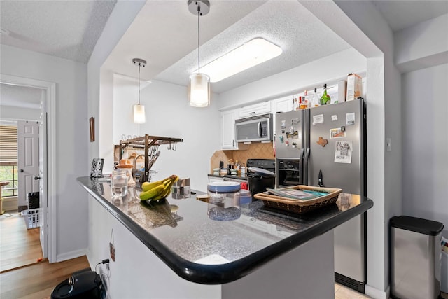 1311 Antoine Dr Unit 254, Houston, TX 77055 - kitchen with stainless steel appliances, white cabinets, tasteful backsplash, a textured ceiling, and a peninsula