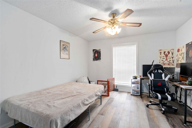 1311 Antoine Dr Unit 254, Houston, TX 77055 - bedroom featuring an office area, wood finished floors, a textured ceiling, and a ceiling fan