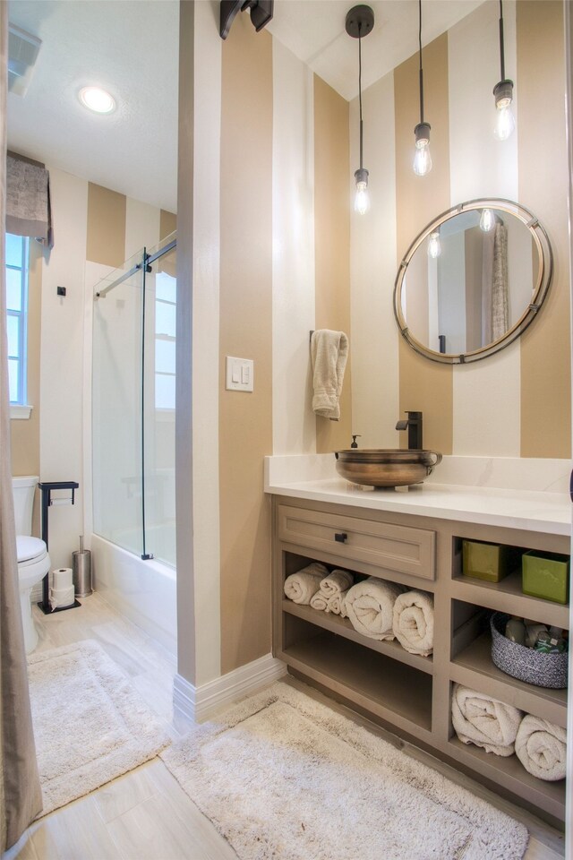 1912 Rollingwood Dr, Huntsville, TX 77340 - bathroom featuring toilet, vanity, enclosed tub / shower combo, baseboards, and recessed lighting