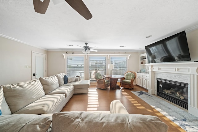 109 Fm-2031, Matagorda, TX 77457 - living room featuring ceiling fan, ornamental molding, wood finished floors, a premium fireplace, and a textured ceiling
