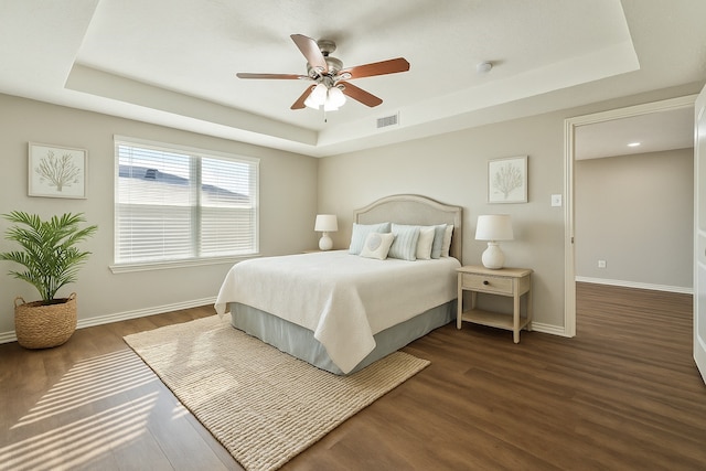 7205 Yucca Dr, Galveston, TX 77551 - bedroom featuring a tray ceiling, dark wood-style floors, baseboards, and ceiling fan