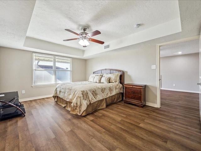 7205 Yucca Dr, Galveston, TX 77551 - bedroom featuring a tray ceiling, a textured ceiling, wood finished floors, baseboards, and ceiling fan