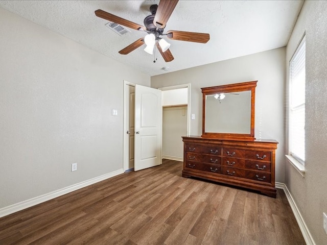 7205 Yucca Dr, Galveston, TX 77551 - unfurnished bedroom with wood finished floors, multiple windows, baseboards, and ceiling fan