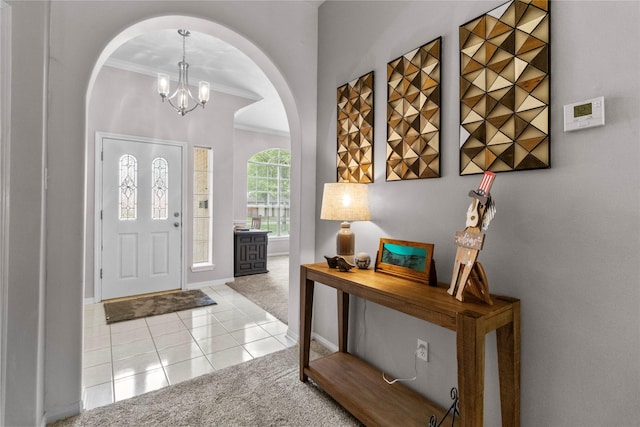 1608 Lark St, Alvin, TX 77511 - carpeted entryway with ornamental molding, arched walkways, tile patterned flooring, a chandelier, and baseboards