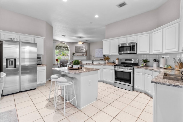 1608 Lark St, Alvin, TX 77511 - kitchen featuring stainless steel appliances, a sink, white cabinets, light tile patterned floors, and recessed lighting
