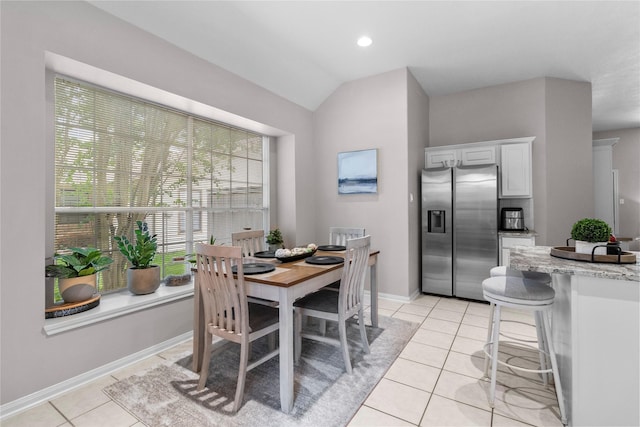 1608 Lark St, Alvin, TX 77511 - dining space with light tile patterned flooring, vaulted ceiling, and baseboards