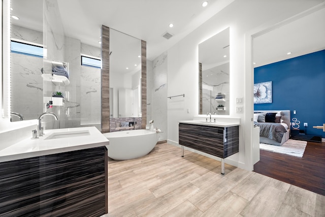 819 W 24th St Unit C, Houston, TX 77008 - ensuite bathroom featuring vanity, a freestanding tub, wood finished floors, and recessed lighting