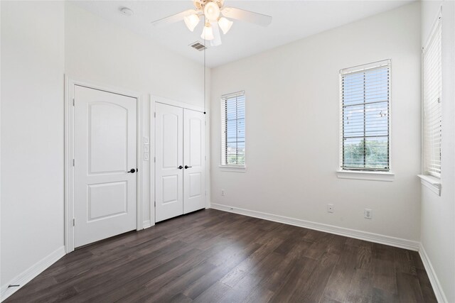 3615 Hempstead Villa Dr, Houston, TX 77008 - unfurnished bedroom with dark wood-type flooring, multiple windows, and baseboards