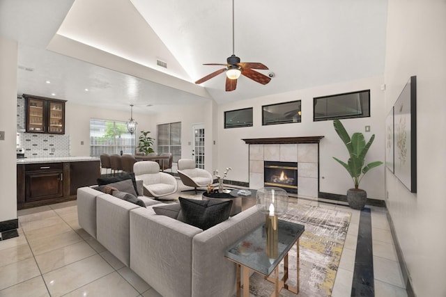 8506 Regalbrook Dr, Houston, TX 77095 - living room featuring light tile patterned floors, a ceiling fan, vaulted ceiling, a tiled fireplace, and baseboards