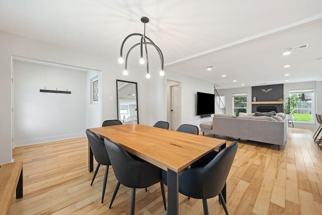 10310 Helmsdale St, Houston, TX 77043 - dining space featuring light wood finished floors, a fireplace, recessed lighting, and baseboards