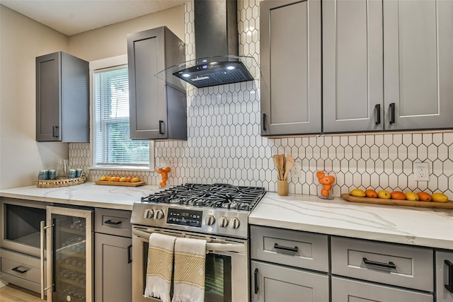 1522 Munger St, Houston, TX 77023 - kitchen with gas stove, wall chimney exhaust hood, beverage cooler, and gray cabinetry