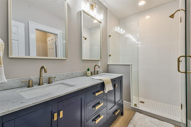 1522 Munger St, Houston, TX 77023 - bathroom with a shower stall, double vanity, wood finished floors, and recessed lighting
