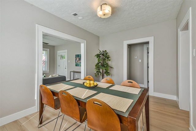 1522 Munger St, Houston, TX 77023 - dining area with light wood finished floors, baseboards, and a textured ceiling