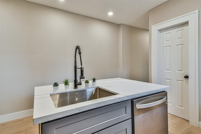 1522 Munger St, Houston, TX 77023 - kitchen featuring gray cabinetry, a sink, dishwasher, light stone countertops, and light wood-style floors