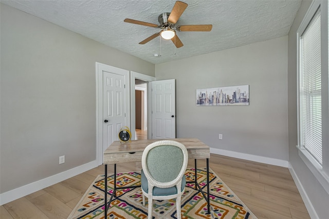 1522 Munger St, Houston, TX 77023 - office area featuring baseboards, a textured ceiling, light wood-style flooring, and ceiling fan